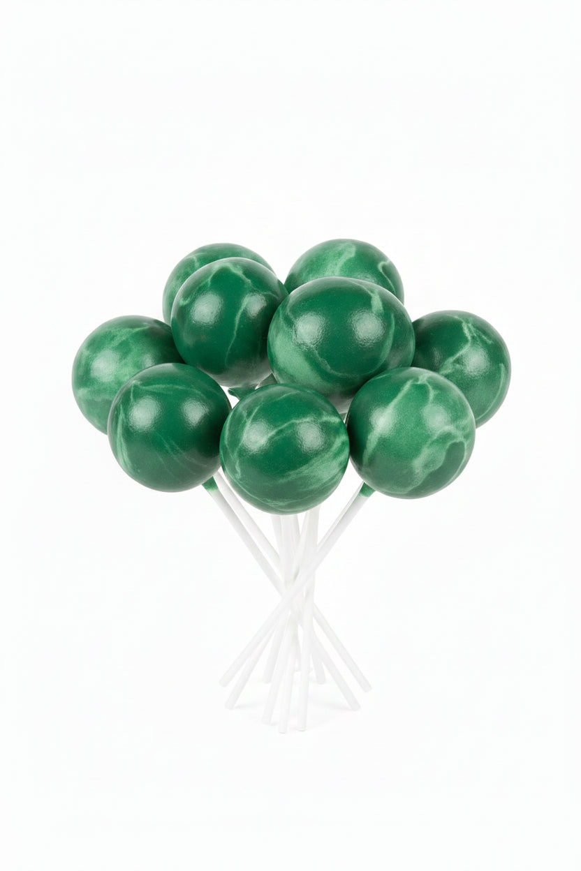 A group of round green cake pops on sticks, packaged inside a clear plastic bag.